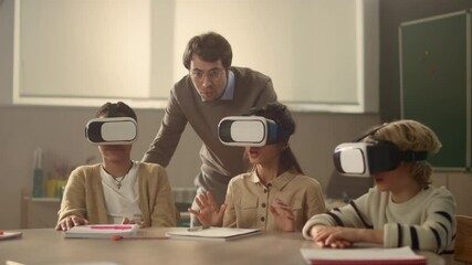 Young schoolteacher explaining students how to use modern gadgets in education - Powered by Adobe