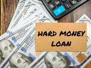 Business concept.Text HARD MONEY LOAN with banknote and calculator on wooden table background.