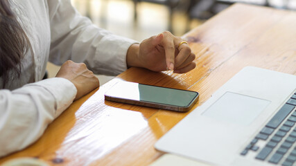 Side view of female hand using smartphone with mock-up screen