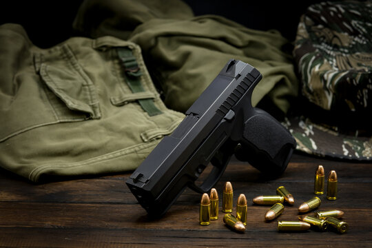 pistol, pistol with ammunition camouflage suit background The concept of weapons and self-defense equipment.
