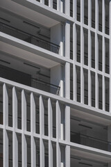 Low angle view of concrete sunshades wall with terrace of modern high residential building in vertical frame