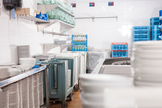 View Of Empty Restaurant Kitchen With Storage Racks Full Of Clean Tableware ..