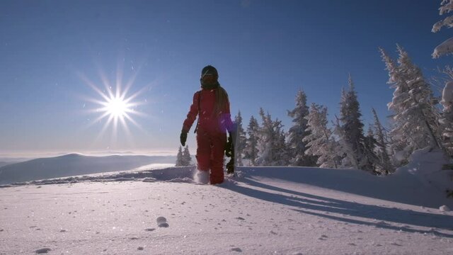 Slow motion video of  snowboarder walking in deep snow 