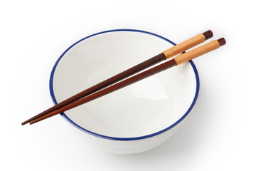 White bowl is empty, and chopsticks are placed on top of the bowl isolated on a white background.
