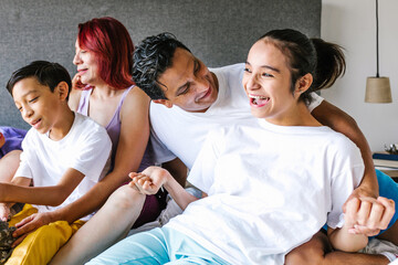 young hispanic girl with cerebral palsy on bed with her father and family in Home in disability concept in Mexico city