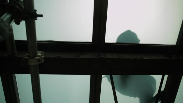 Silhouette of a construction worker on the ceiling.