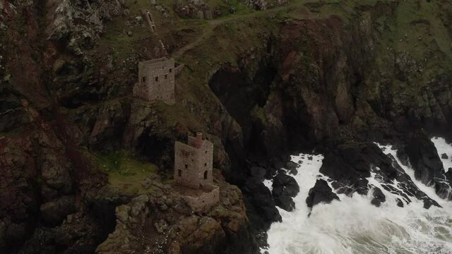 Aerial orbit around the pump house of the tin mines where the Atlantic meets the stone Cornwall coast.