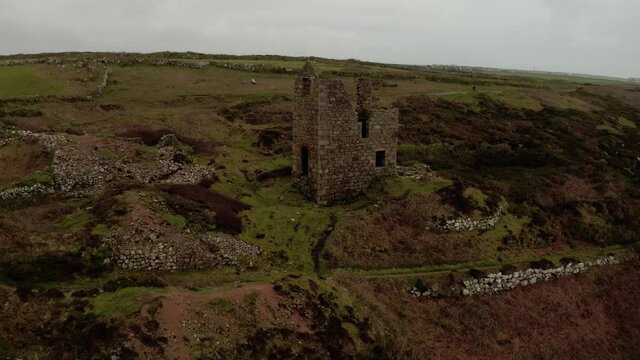 Aerial rotation on a large stone ruin of the pump house on the Cornish coast, Cornwall, United Kingdom.