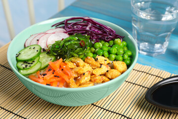 Delicious salad with chicken, vegetables and seaweed on light blue table, closeup