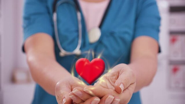 Medicine doctor or nurse holding red beating heart shape in hand - modern virtual imaging interface, medical technology and cardiovascular health awareness concept