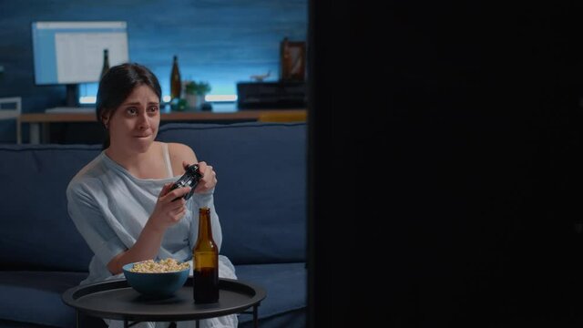 Determinated excited woman sitting on sofa playing video games, happiness screaming raising hands enjoying winning online competition. Competitive gamer using controller joysticks playstation gaming