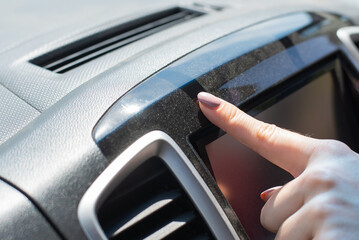 Wipe dust off car dashboard with finger.