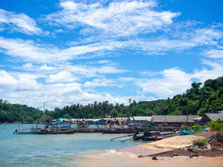 Fototapeta na wymiar Beautiful seascape summer background. Scene of fisherman village with many local longtail boat on the sea and sky background on a sunny day in Thailand.