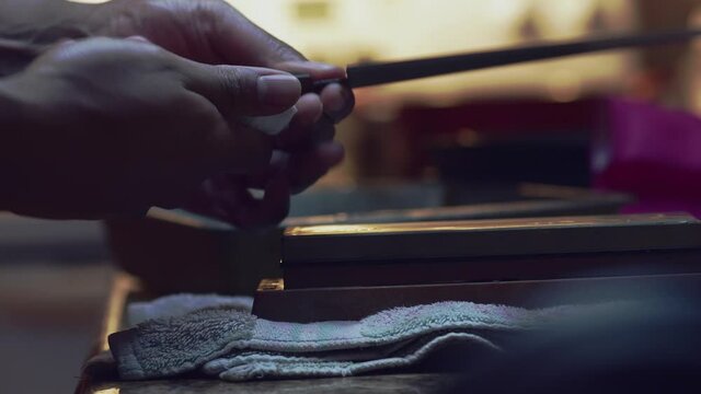 A man inspects and oils a 240mm gyuto knife.