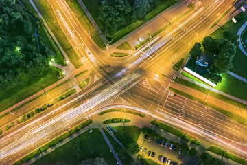 aerial top view of crossroad in city at night with car light trails