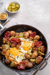 Potato hash with fried eggs and meat pastrami for breakfast branch
