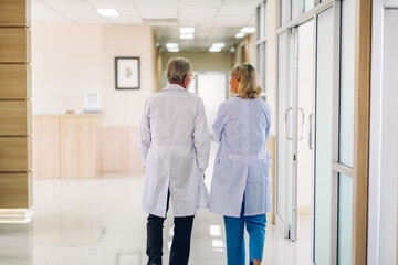 Group of professional medical doctor team with stethoscope in uniform working discussing and talk walking in hospital.health medical care concept