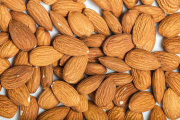 Background of big raw peeled almonds situated arbitrarily. Top view. Macro photography