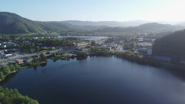 Sunny morning view over Liavatnet freshwater with highway and industry in background - Morning aerial view Asane Bergen Norway