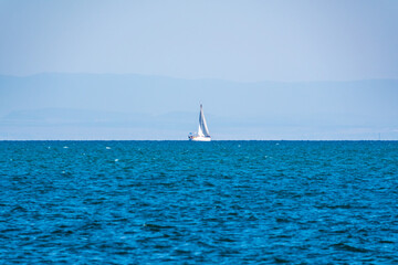 Sailing yacht in the blue calm sea.