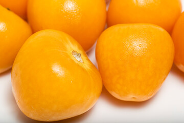 Bunch of bright yellow ripe Cape goldenberries isolated on white background. Macro photography.