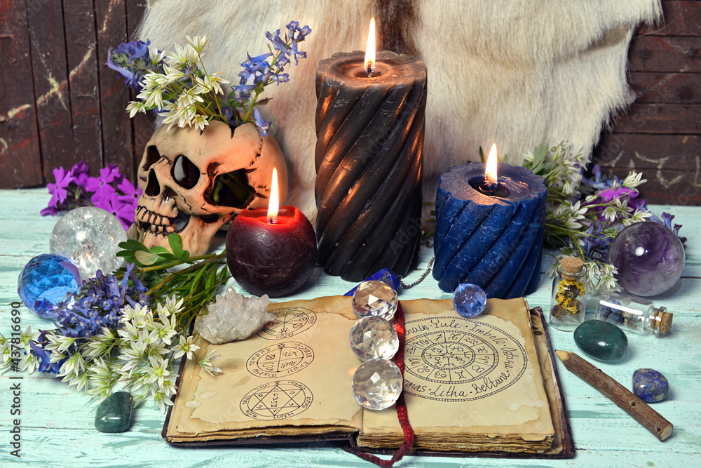 Wall mural still life with open book wiccan holidays and symbols, flowers, crystal and burning candles.