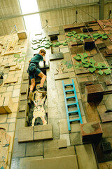 Obraz na płótnie Canvas teen boy on indoor climbing wall, bourdering