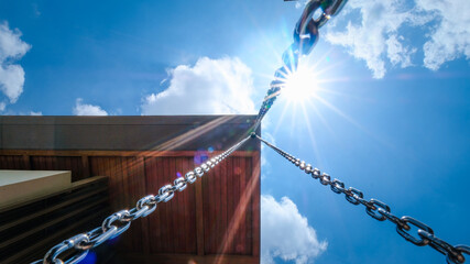 Steel chains are used as rain gutters. Intentional sun glare and lens flares. 