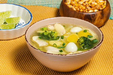 Chicken ginseng soup with broccoli, quail eggs, lemon and toasted peruvian corn. Traditional food.