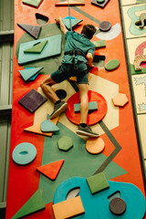 teen boy on indoor climbing wall, bourdering