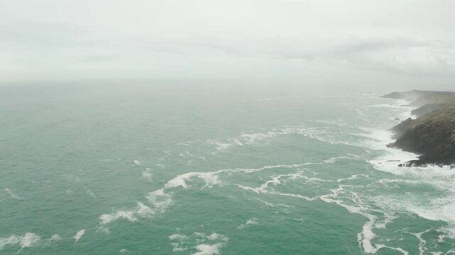 Aerial rotation from the open Atlantic Ocean to the wild misty Cornish coast. 