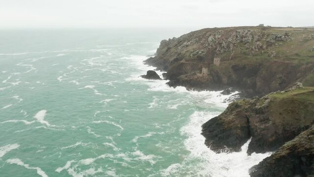 Aerial pass along the Cornwall coastline where the National Trust keeps the tin mine buildings open to the public.