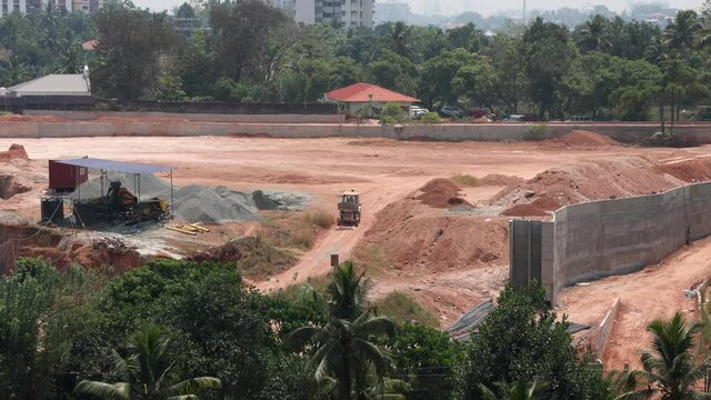 Construction site of building , Work going in Kerala India JCB excavators, concrete mixer at the worksite 4K slow motion footage Land filled moved Landscape transformation to urban area with machinery
