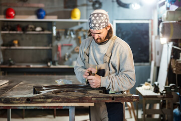 Male carpenter working on old wood in a retro vintage workshop.