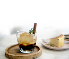 Round ice cube in black coffee espresso serve with cinnamon stick in cafe white light copy space