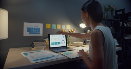 Young asia business lady freelance open laptop computer getting ready to start work on wooden desk in living room at house night. Work from home, remotely, social distance quarantine for coronavirus.