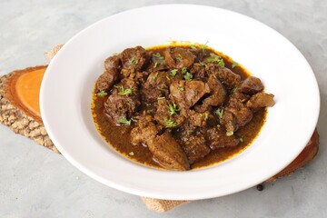 Chicken Liver Masala or Kaleji fry garnished with coriander. Liver fry is a very popular Nonvegetarian Indian dish. Made from Chicken liver. White background. copy space with spices.