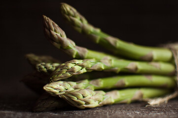 Bunch of fresh green asparagus on dark wooden table, healthy eating, seasonal products