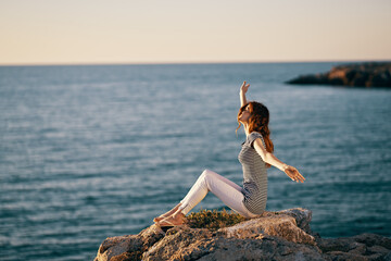 woman in a striped T-shirt raised her hands up near the sea in peas
