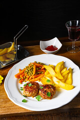 Homemade meatballs with french fries and vegetables
