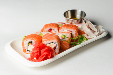 California or Philadelphia sushi rolls set served on a white tray over white background. Japanese cuisine concept
