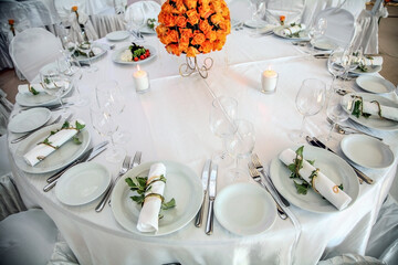 Holiday table setting decorated with flowers and candles.