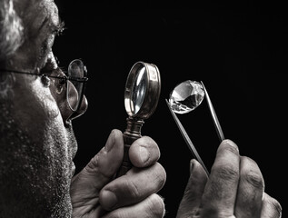 Large gemstone in jeweler's hand close up. Gem identifying and evaluating process.