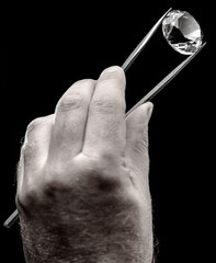 Large gemstone in jeweler's hand close up. Gem identifying and evaluating process.