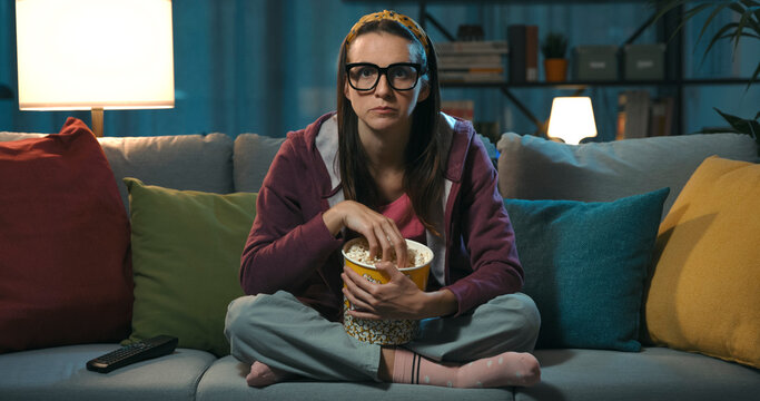Woman watching TV and eating popcorn © stokkete