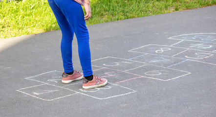 kid playing hopscotch on playground outdoors, children outdoor activities