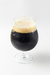 Full beer tulip glass of stout or porter isolated on white background. Beer in a glass, alcoholic beverage
