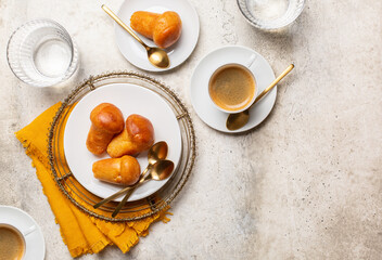 Italian breakfast. Rum baba and coffee espresso, glasses of water.  Light stone background, top view, copy space.