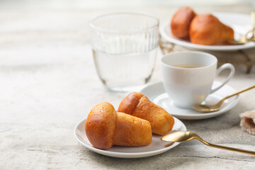 Italian breakfast. Rum baba and coffee espresso, glass of water. Selective focus. Light background.