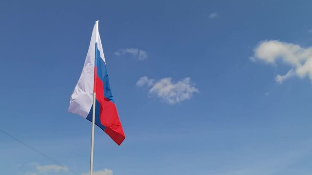 Russia. National country flag on blue sky background. Flying fabric symbol. Tourism or travel summer day. international patriotic emblem. Nobody. Horizontal video
